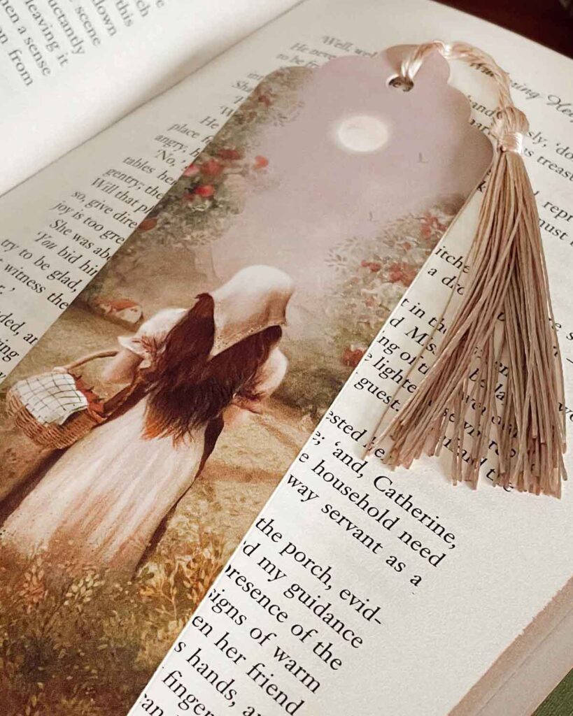 Illustrated bookmark showing a girl in a white dress and head scarve walking through a meadow under a harvest moon, with a blush tone tassel.