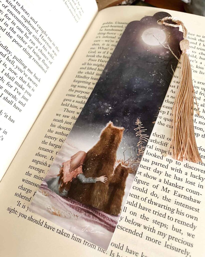 Illustrated bookmark of a girl in a warm shawl resting against a bear under a snowy night sky, with a pale pink tassel.