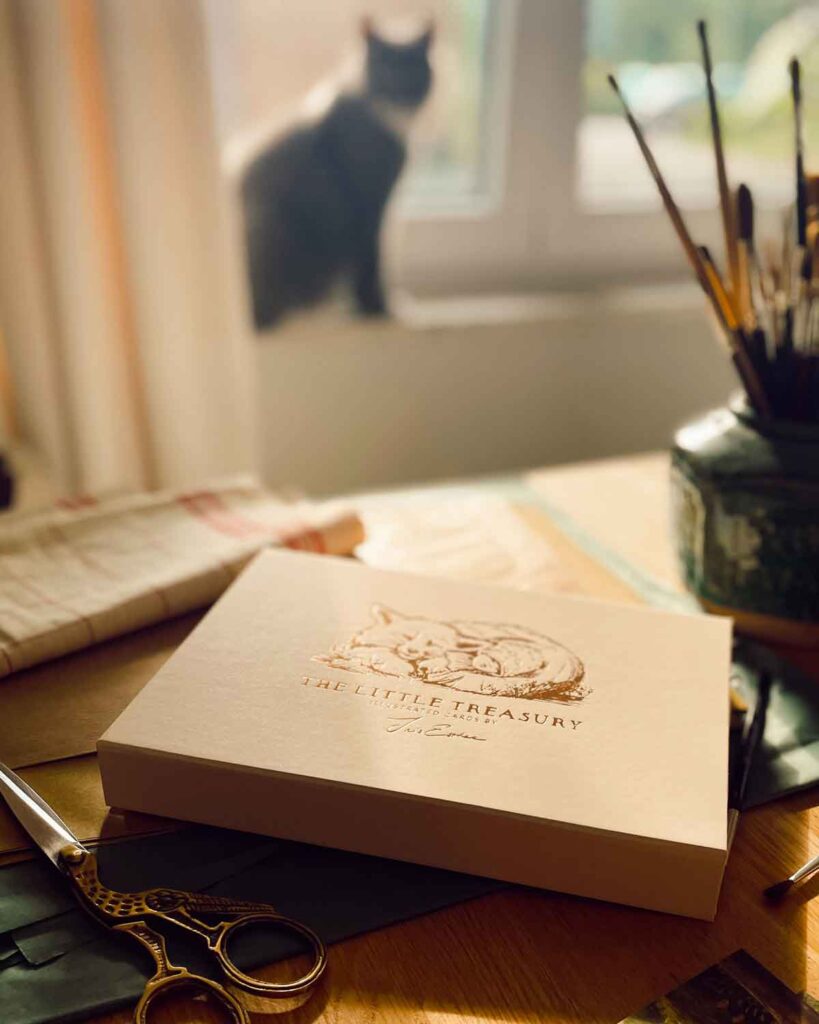 beige giftbox with golden print containing 80 postcards