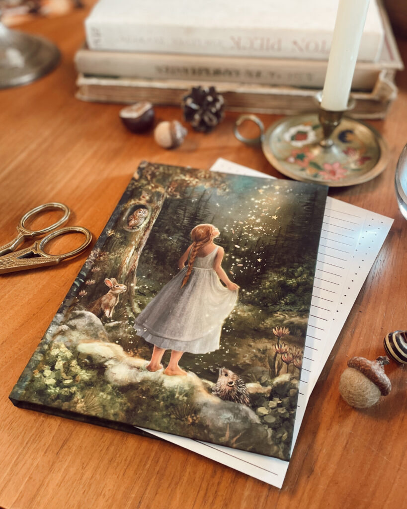 Illustrated stationery notebook with girl, owl, rabbit and hedgehog in a woodland scene